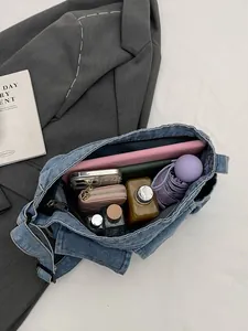 Large capacity vintage washed blue denim shoulder bag showing spacious storage for daily items