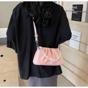 Detail van een lichtroze geplooide cloud-bag met acryl kralen en een leren riem