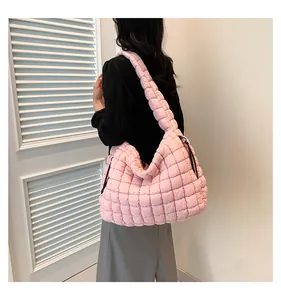 Detail van zachte roze gewatteerde bubbeltas met gewatteerde riem en zwart trekkoord detail