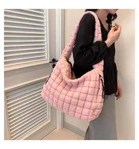 Roze gewatteerde bubble tas gedragen door model, met zachte textuur en nylon ontwerp