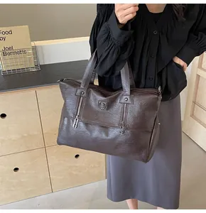 Deep brown pebble leather tote bag with zip detail styled for professional daily commute