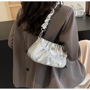 Zilveren geplooide cloud-tas met grote transparante kralenketting en metallic-look leer