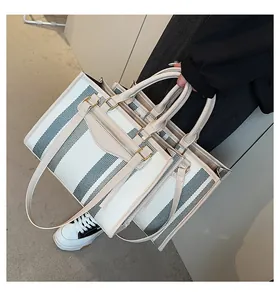 Detail van de canvas tote bag set met gestreepte textuur en luxe lederen handvaten
