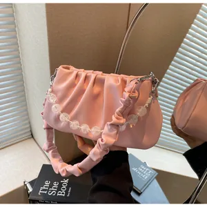 Macro-opname van roze geplooide cloud bag met decoratieve matte kralenketting voor dames