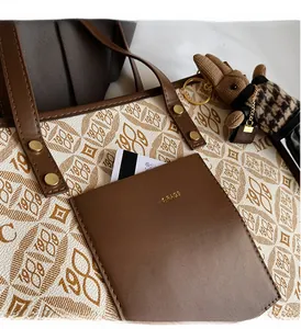 Detail of canvas tote with brown leather pocket and gold embossed 1989 pattern