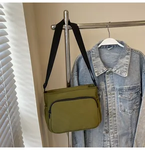 Détail du sac bandoulière en nylon vert armée avec poche zippée et sangle réglable