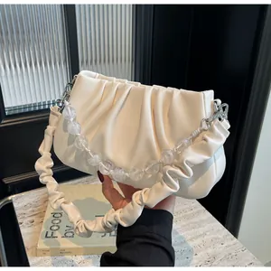 Detail van de gebroken witte geplooide wolkentas met transparante kralenband en zacht kunstleer