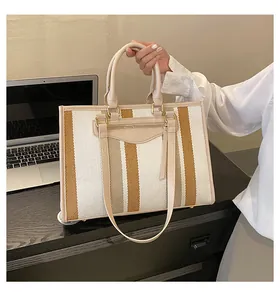 Detailweergave van grote canvas tote bag met streeppatroon en kunstlederen bies