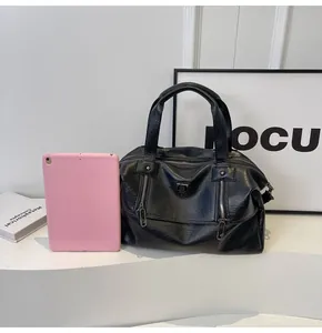 Detailed view of black PU leather Boston tote bag next to a tablet for size reference
