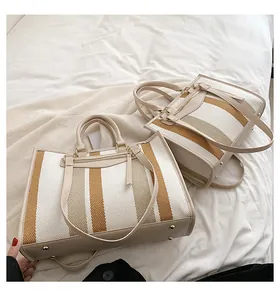 Detailopname van grote canvas shopper met retro strepen en metalen bodembeschermers
