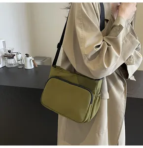 Détail du sac bandoulière en nylon vert olive avec sangle réglable et poche à cordon serrage