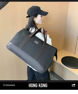 Detail of canvas travel bag with leather corners and fashion label carried by model