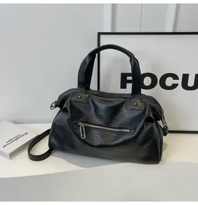 Detail of black soft PU leather tote bag with zip pocket and dual top handles