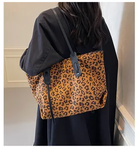 Detailed back view of a large leopard print tote bag styled with a black coat