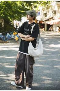 Male model wearing a white nylon crescent hobo bag for outdoor casual streetwear style