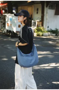 Detail of blue crescent nylon crossbody bag with side woven knot ornament