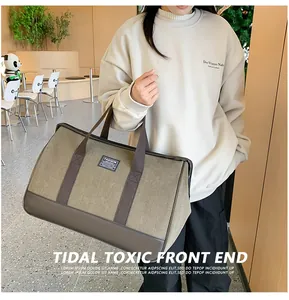 Detail of army green canvas travel bag with sturdy leather handles and fashion logo