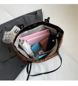 Top view of spacious leopard print tote interior with multiple storage pockets and laptop space