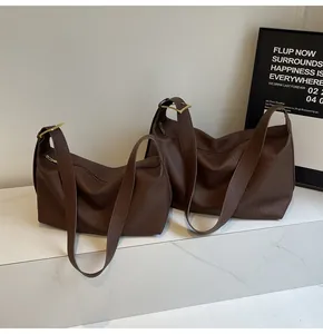 Détail de deux sacs hobo marron café avec d'élégantes boucles en métal doré poli