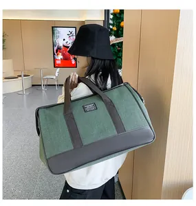 Detail of green canvas travel bag with leather accents and Fashion patch detail