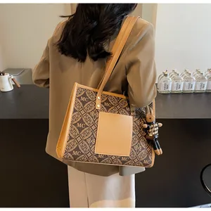 Detailed back view of brown monogram tote bag with a small rabbit plush charm