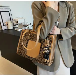 Detail of printed tote bag featuring a brown rabbit charm in a modern interior setting