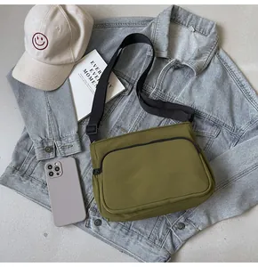 Détail de la sacoche en nylon vert armée avec bandoulière réglable et poche zippée pratique