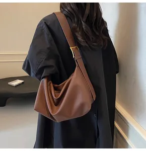 Sac sous le bras en cuir marron à texture litchi et bandoulière large sur modèle