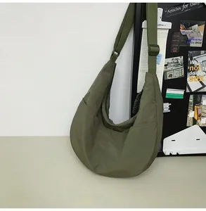 Close-up of olive green nylon crescent bag with adjustable strap and metal hardware
