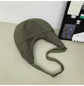 Detail of olive green nylon dumpling bag showing high-quality fabric and adjustable strap