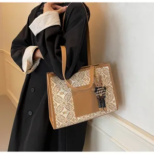Detail of vintage beige tote bag featuring geometric patterns and brown rabbit charm