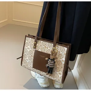 Detail shot of vintage tote bag with MC 1989 pattern and cute rabbit plush accessory