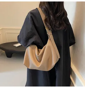 Détail du sac à épaule en similicuir abricot avec large bandoulière et boucle dorée