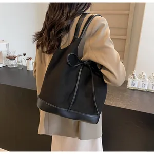 Detail of black bow frosted tote bag showing spacious design and matte texture finish