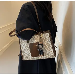 Detail of vintage monogram tote bag with rabbit charm and fashion leather branding