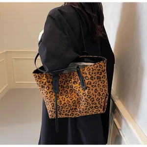 Chic leopard print tote bag with black slim straps shown on a model for fashion context