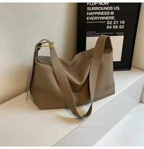 Gros plan d'un sac cabas souple café avec texture plissée et boucle en métal doré