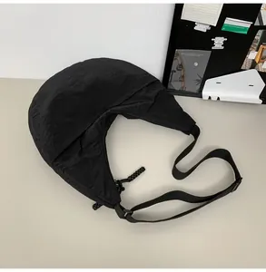 Detailed top view of a matte black nylon crescent bag showing fabric texture and shape