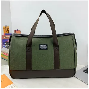 Detail of olive green canvas travel bag with brown leather base and reinforced handles