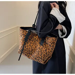 Detail of a large leopard print tote bag shown on a model for casual autumn fashion style
