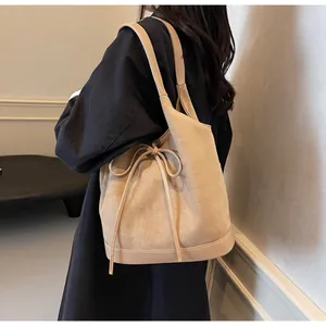 Detail of light tan bow tote bag showing matte texture and splicing on the shoulder strap