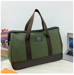Detail of large canvas travel bag showing olive fabric and durable leather handles
