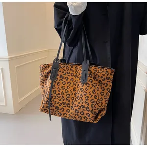 Close-up of large leopard print tote bag in soft velvet canvas with black leather straps