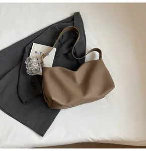 Détail du cuir grainé marron souple et du design plissé chic du sac à bandoulière vintage