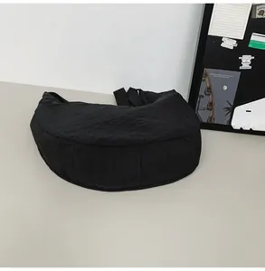 Side view of large black waterproof nylon crescent bag with adjustable strap and wide base