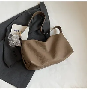 Texture détaillée d'un sac à bandoulière en cuir marron au design souple plissé
