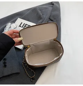 Detail view of the quilted dark brown leather bag showing spacious beige fabric interior