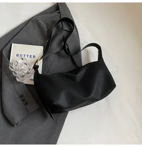 Gros plan d'un sac porté épaule noir en forme de demi-lune avec texture en cuir