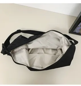 Detailed interior of nylon crossbody bag featuring gray lining and zipper pocket