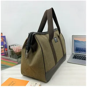 Macro view of olive canvas travel bag with reinforced leather handles and metal zipper detail